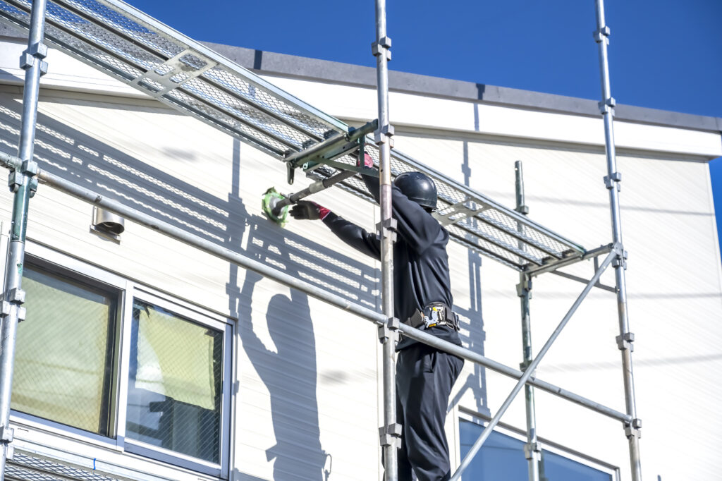 外壁塗装する男性